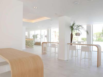 Světlý, moderní společenský prostor s velkými okny a vysokými stoly