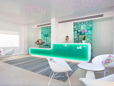 Moderne Hotellobby mit elegante Theke und stilvollen Sitzgelegenheiten in hellem Ambiente.