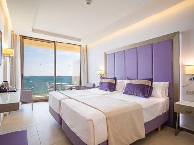 Camera d'hotel moderna con due letti e vista mare attraverso grandi finestre