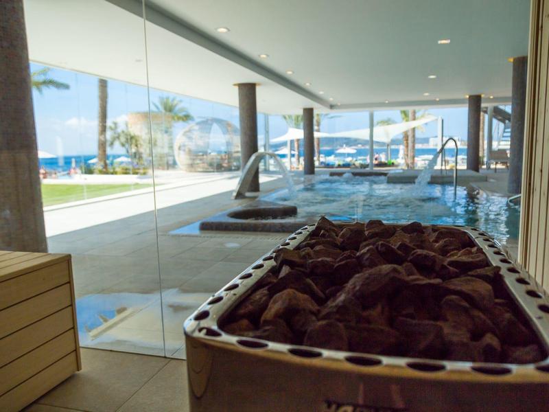 Struttura per vacanze moderna con spazio aperto, calcetto e finestre panoramiche con vista sul mare.