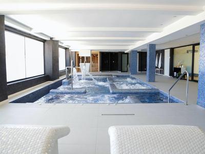 Innenpools mit Wasserspielen und breiten Fenstern, helle moderne Architektur mit glattem Boden.