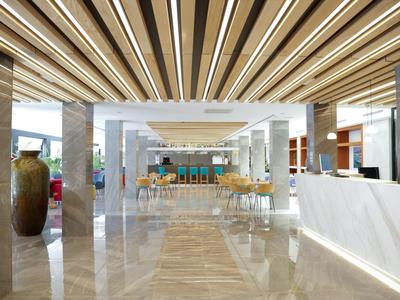 Modern hotel lobby with bright lighting, shiny marble floor, and contemporary furniture.