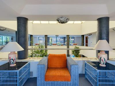 Modernes, helles Wohnzimmer mit orangenem Sessel und blauen Tischlampen auf Seitentischen.