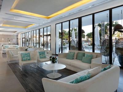 Helle Hotellounge mit großen Fenstern und bequemen Sofas in sanften Farben.