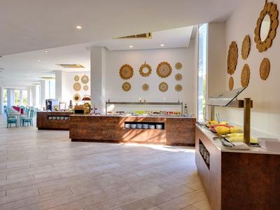 Großer heller Raum mit Buffet, Wanddekoration aus Körben und modernen Holzmöbeln.