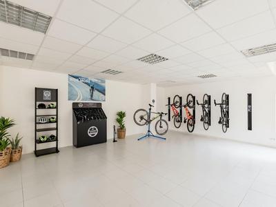 Moderner Fahrradraum mit Wandhalterungen und Reparaturplatz in hellen Räumen.