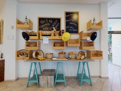 Modern dekorierter Brot- und Gebäckverkaufsbereich mit Holzregalen und blauen Hockern.