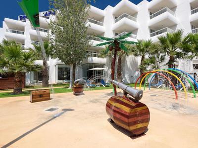 Kinderspielplatz mit Kanone und Bogen vor einem weißen Hotelgebäude