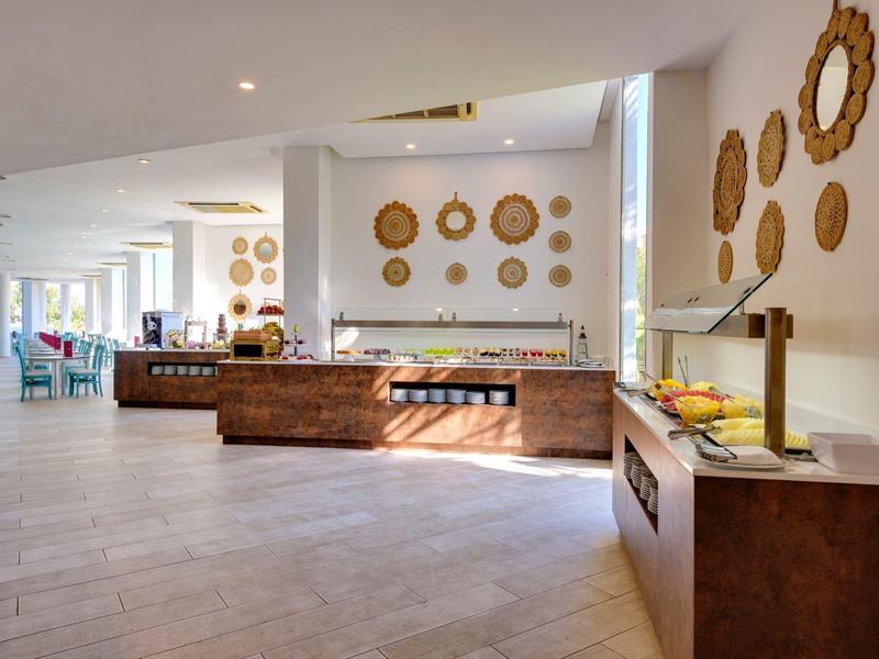 Großer heller Raum mit Buffet, Wanddekoration aus Körben und modernen Holzmöbeln.