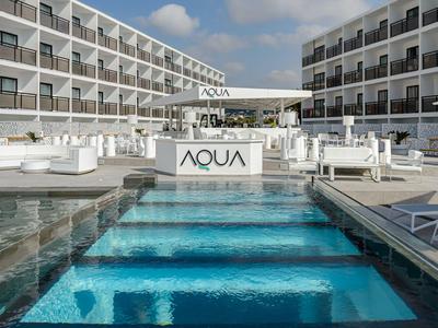 Piscina moderna dell'hotel con lettini e edifici bianchi sotto un cielo blu sereno