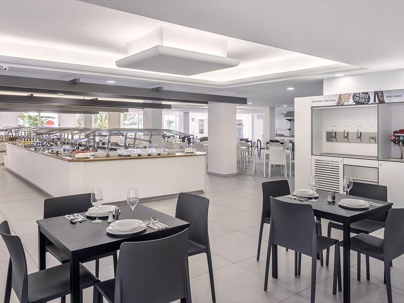 Moderne, lichte eetruimte met zwarte stoelen en gedekte tafels in een hotel.