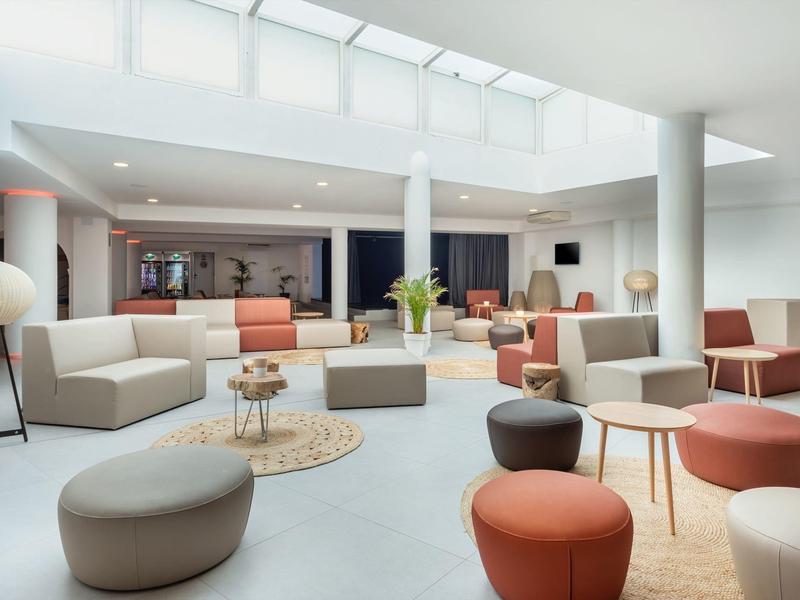 Heldere, moderne hotel-loungeruimte met comfortabele zitplaatsen en daglicht van grote ramen.