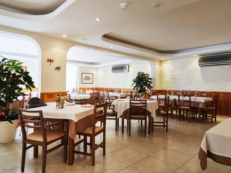 Elegantní jídelna s bílými ubrusy a dřevěným nábytkem v hotelu.