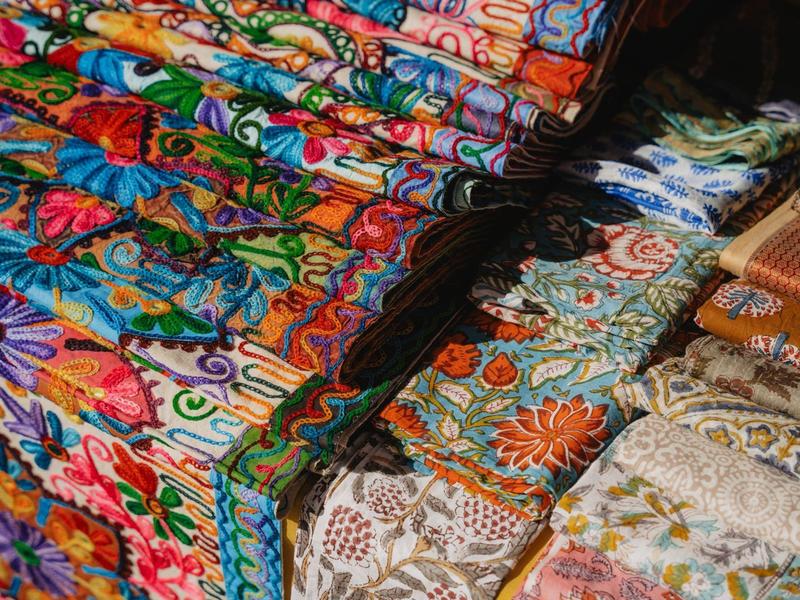 Kolorowe tkaniny w wzory rozłożone na stoisku na targu