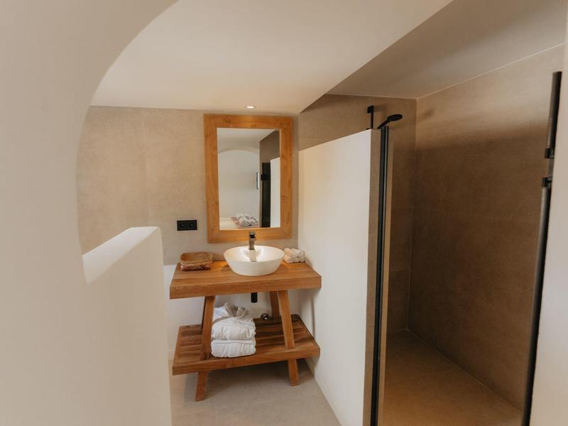 Nowoczesna łazienka z drewnianą umywalką i ręcznikami pod umywalką.