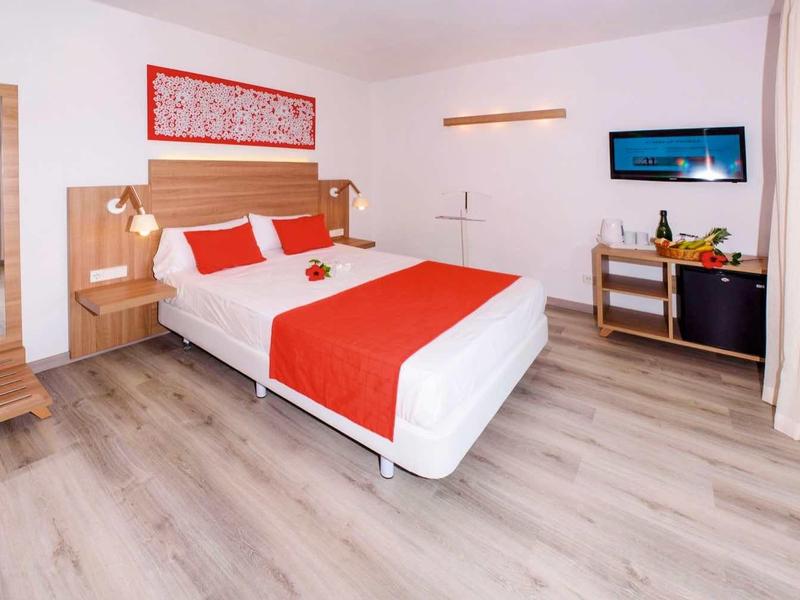 Nowoczesny pokój hotelowy z łóżkiem podwójnym, telewizorem i balkonem