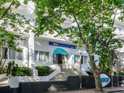 Budynek hotelu z tarasem, drzewami i schodami na pierwszym planie w świetle dziennym