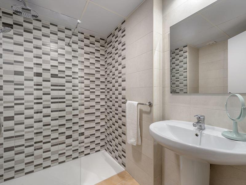 Nowoczesna łazienka z białą umywalką i czarno-białą wzorzystą ścianą prysznicową.