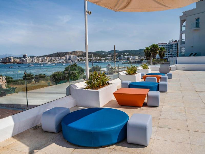 Nowoczesne zewnętrzne miejsca do siedzenia z kolorowymi poduszkami z widokiem na morze i miasto.