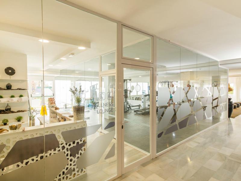 Ruime, lichte fitnessruimte in hotel met moderne apparatuur en glazen wanden.