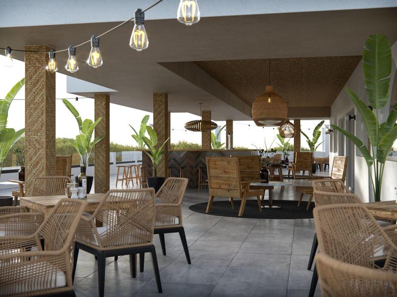 Lichte hotelrestaurant met rotan stoelen, grote planten en hanglampen.