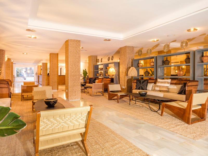 Heldere, moderne hotel lobby met comfortabele fauteuils en warme houten accenten.