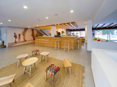 Moderne hotel lobby met bar en diverse zitplaatsen op tapijt.