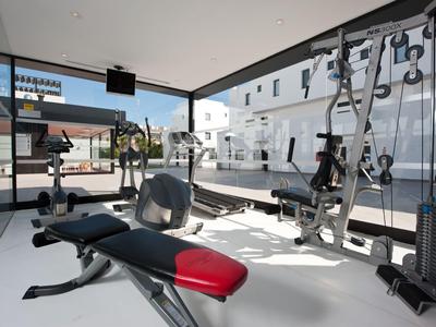 Modern gym with various workout equipment in a bright, spacious room.