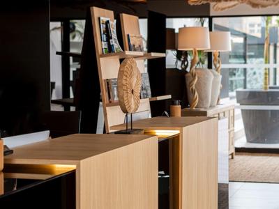 Modern hotel reception area with light wooden furniture and stylish lighting fixtures.