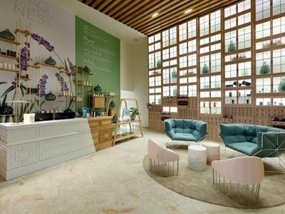 Modern hotel lobby with large windows, green wall art, reception desk, and cozy seating area.