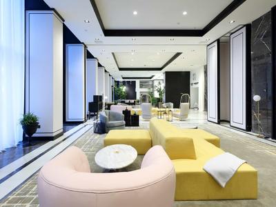 Modern hotel lobby with colorful, curved sofas and bright lighting.