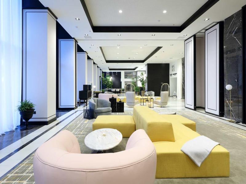 Modern hotel lobby with colorful, curved sofas and bright lighting.
