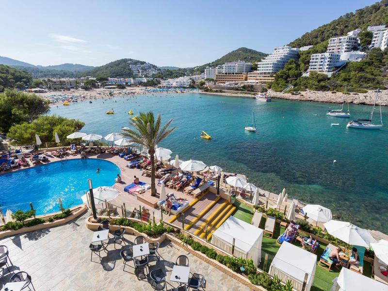 Bazen a terasa s výhledem na živý záliv obklopený kopci a hotely.