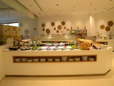 Buffet met verse groenten, vleeswaren en brood in een lichte eetzaal