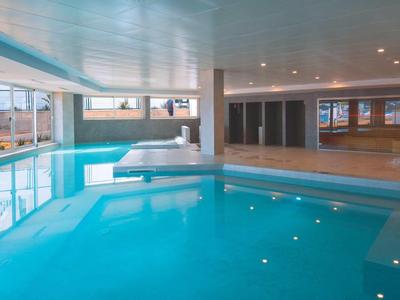 Licht binnenzwembad met grote ramen en modern interieur in een hotel.