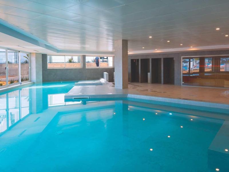 Licht binnenzwembad met grote ramen en modern interieur in een hotel.