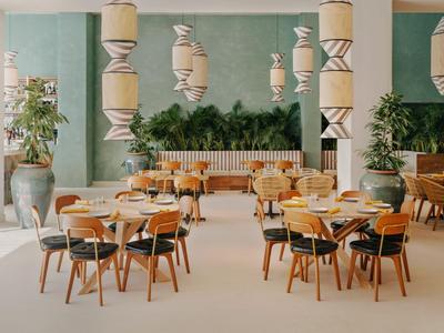 Modern eingerichteter Hotelrestaurantbereich mit runden Holztischen und stilvollen Leuchten.