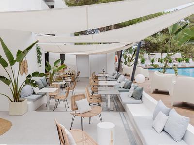 Moderne buitenruimte met zitplaatsen en zwembad onder witte zonneschermen.