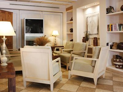 Světý obývací pokoj s pohodlnými křesly, vestavěnými policemi a teplým osvětlením.