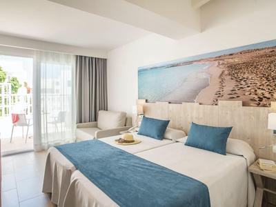 Moderní dvoulůžkový pokoj s balkonem, výhledem na moře a uklidňujícími modrými akcenty.