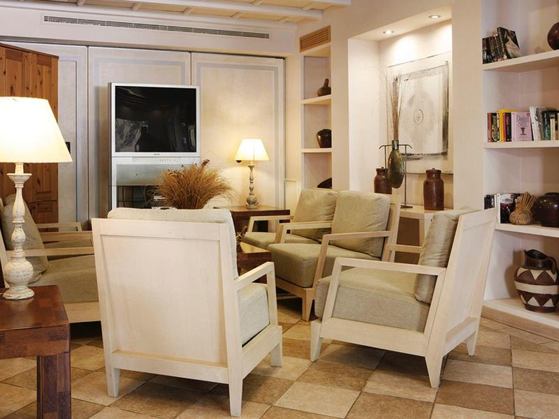 Světý obývací pokoj s pohodlnými křesly, vestavěnými policemi a teplým osvětlením.