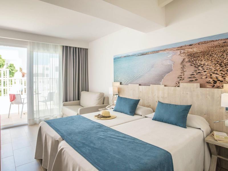 Moderní dvoulůžkový pokoj s balkonem, výhledem na moře a uklidňujícími modrými akcenty.