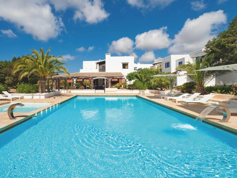 Nowoczesny hotelowy basen z leżakami i niebieskim niebem w tle.