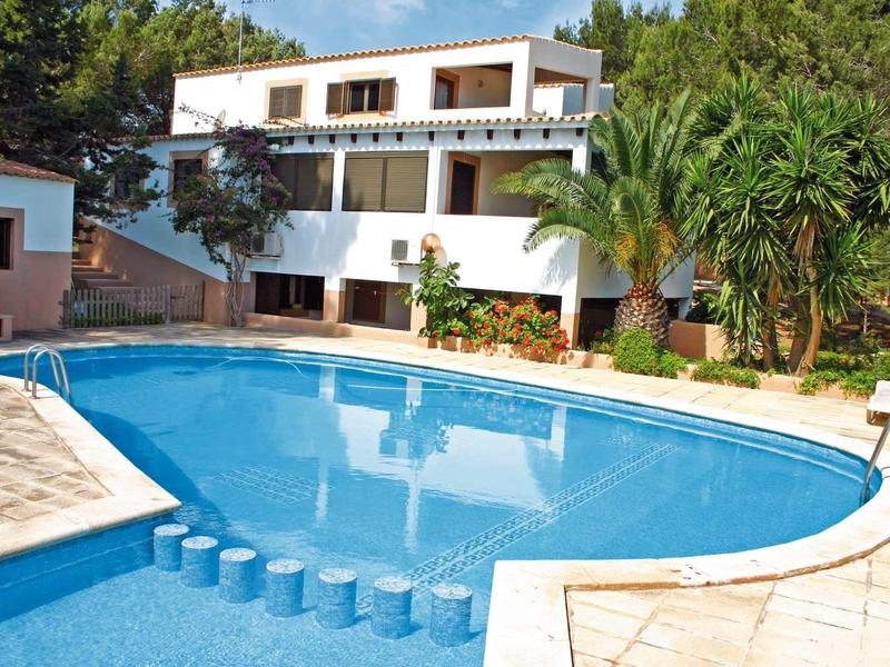 Modern multi-story building next to a large round swimming pool with blue edging