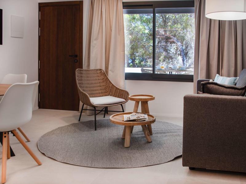 Przytulny kącik do siedzenia z krzesłami, sofą i okrągłym dywanem w nowoczesnym pokoju.