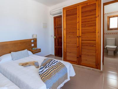Una habitación de hotel con dos camas individuales, muebles de madera y baño adjunto.