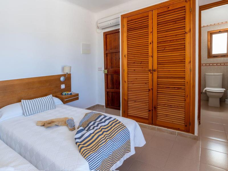 Una habitación de hotel con dos camas individuales, muebles de madera y baño adjunto.