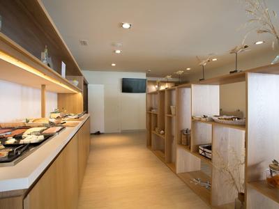 Modern breakfast room with buffet and seating areas in light wood design.