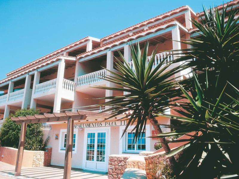 Edificio di hotel su più piani con balconi e piante verdi in primo piano