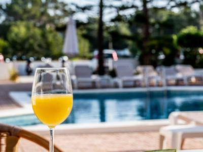 Glas Orangensaft und Teller mit Wassermelone und Ananas am Pool im Freien.